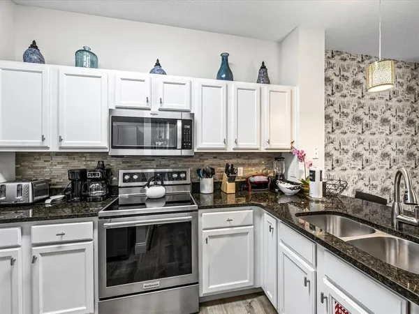 a kitchen with stainless steel appliances a stove a sink and a microwave