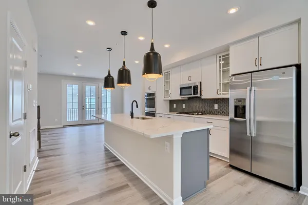 a kitchen with stainless steel appliances a refrigerator sink and microwave