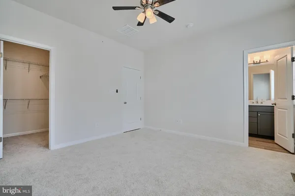 a view of an empty room with a ceiling fan