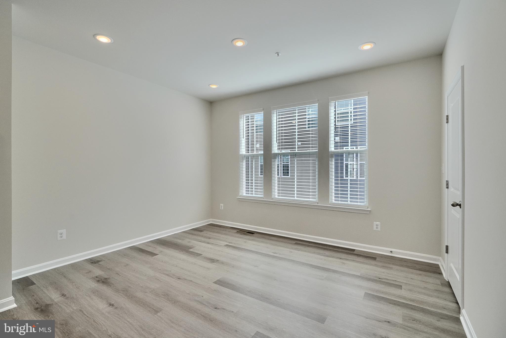 2509 Gatwick Lane, Unit 60 Frederick, MD 21701 - Photo 10 of 30 a view of an empty room with wooden floor and a window
