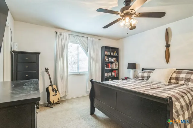 a bedroom with a bed and a flat tv screen on dresser