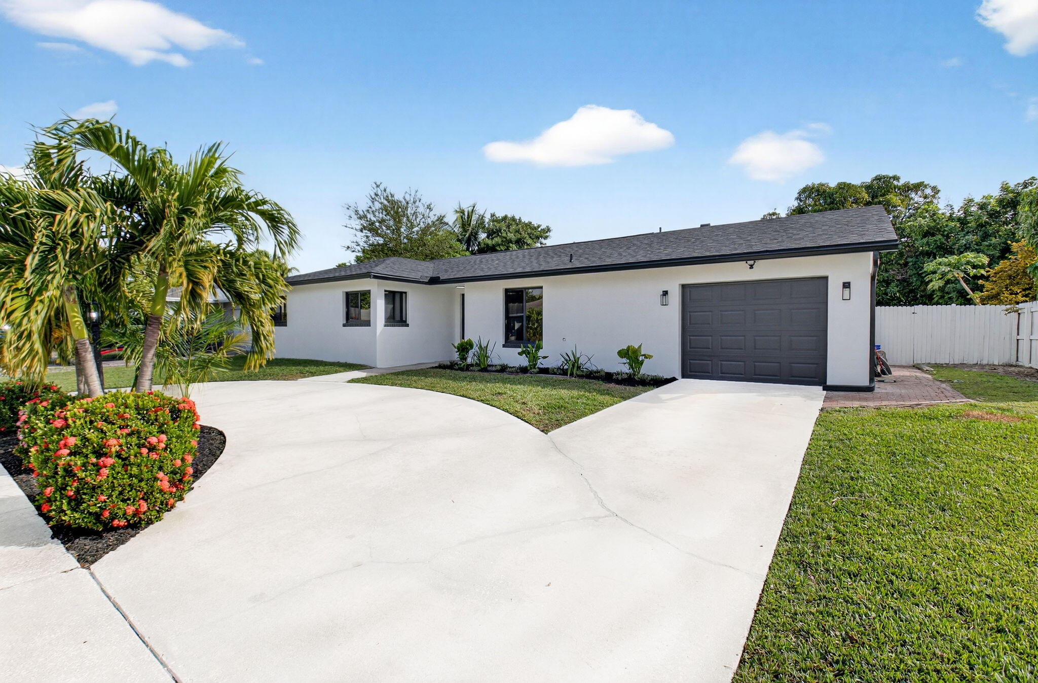 10151 Windtree Lane Boca Raton, FL 33428 - Photo 1 of 39 a front view of a house with a garden and yard