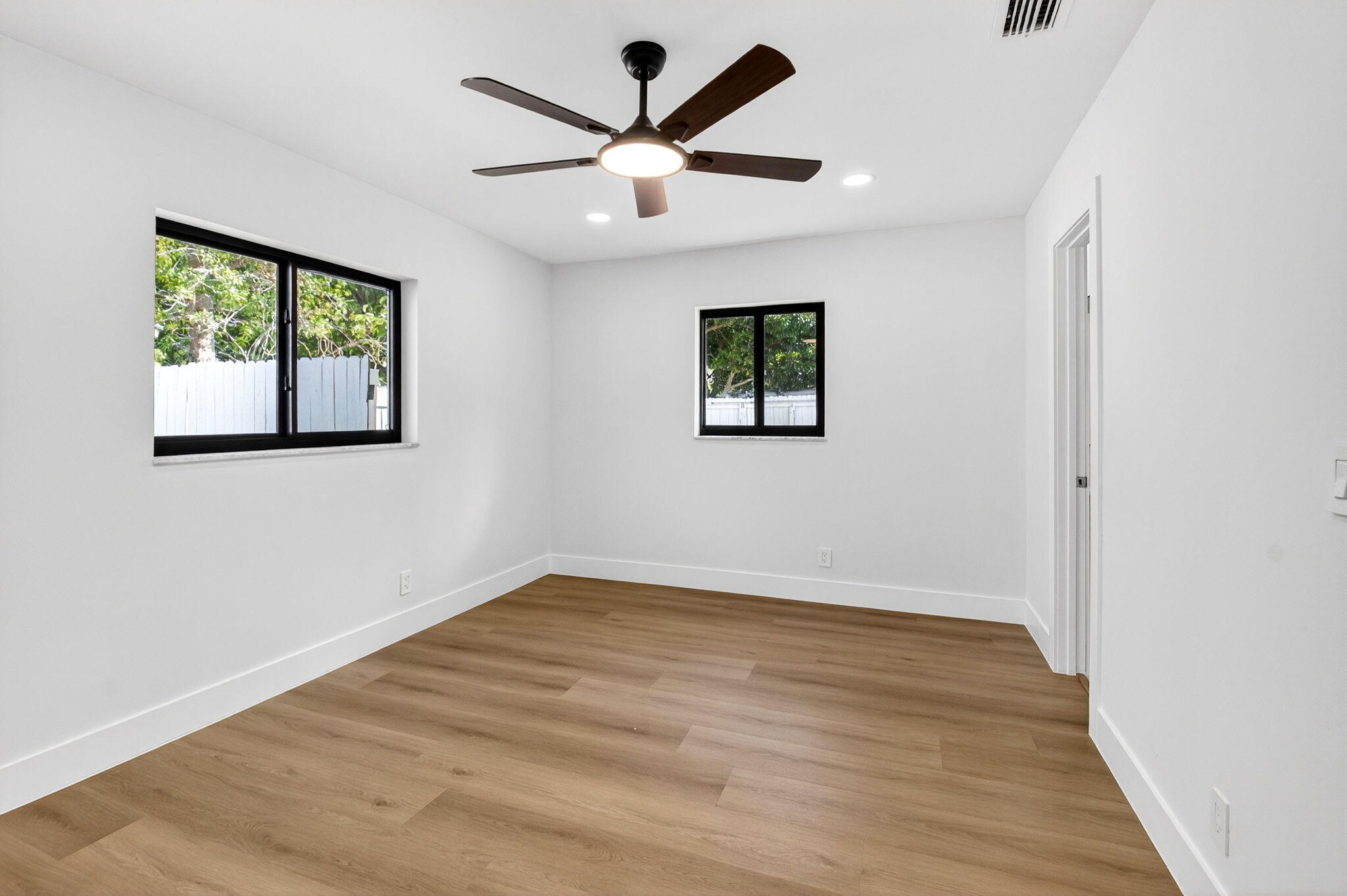 10151 Windtree Lane Boca Raton, FL 33428 - Photo 20 of 39 an empty room with wooden floor and windows