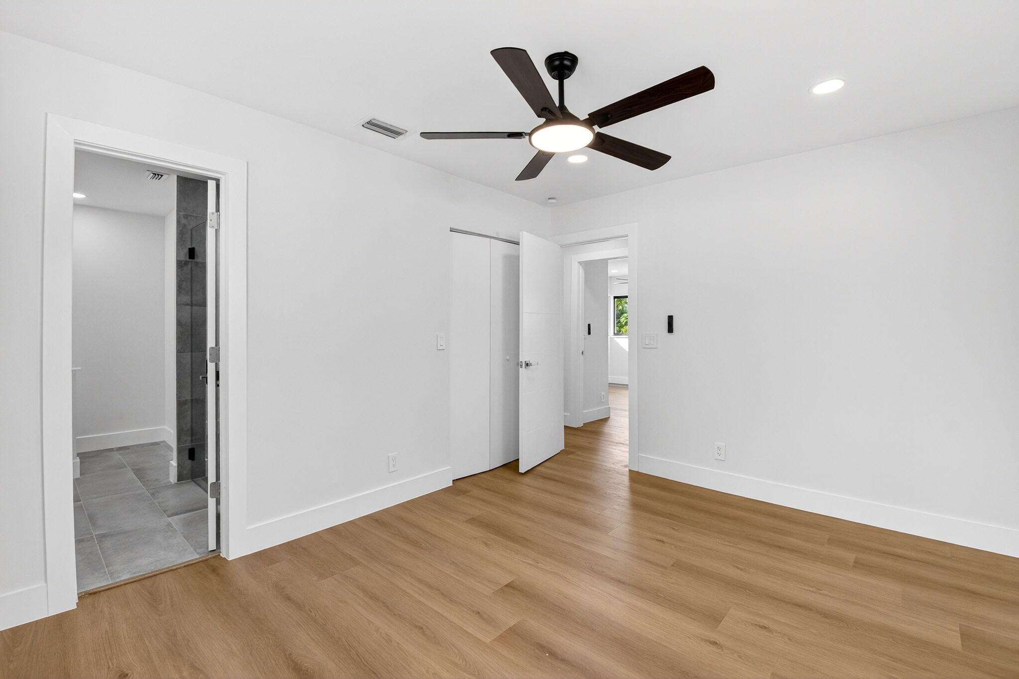 10151 Windtree Lane Boca Raton, FL 33428 - Photo 23 of 39 an empty room with wooden floor and a ceiling fan