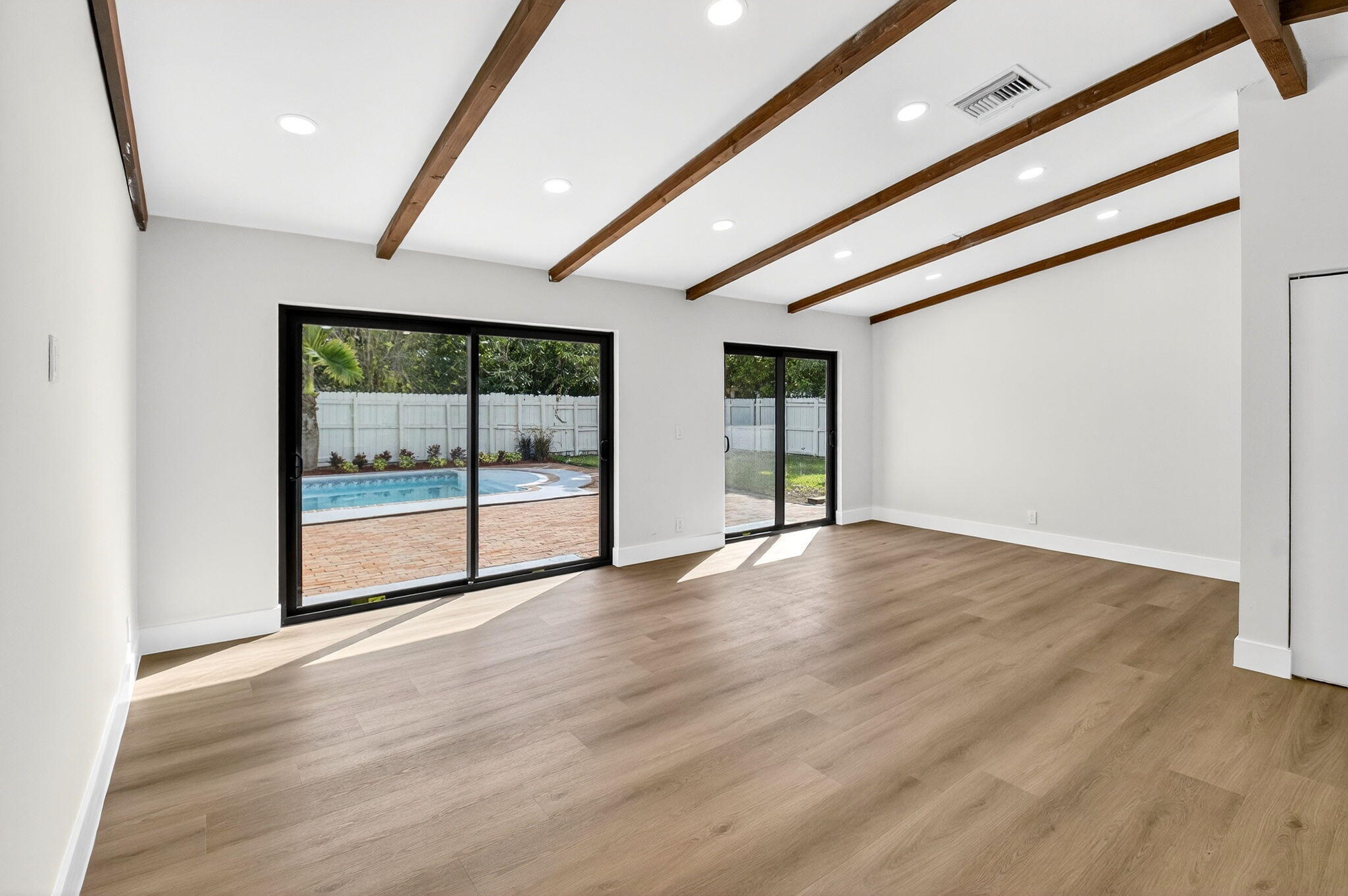 10151 Windtree Lane Boca Raton, FL 33428 - Photo 8 of 39 a view of an empty room with wooden floor and a window