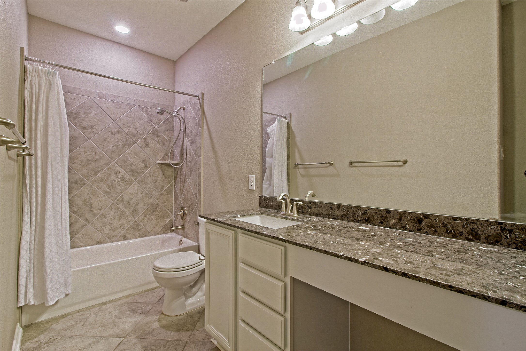 31443 Kingsway Road Georgetown, TX 78628 - Photo 22 of 40 A well-appointed bathroom features a single vanity with ample counter space and a tiled shower-tub combination.