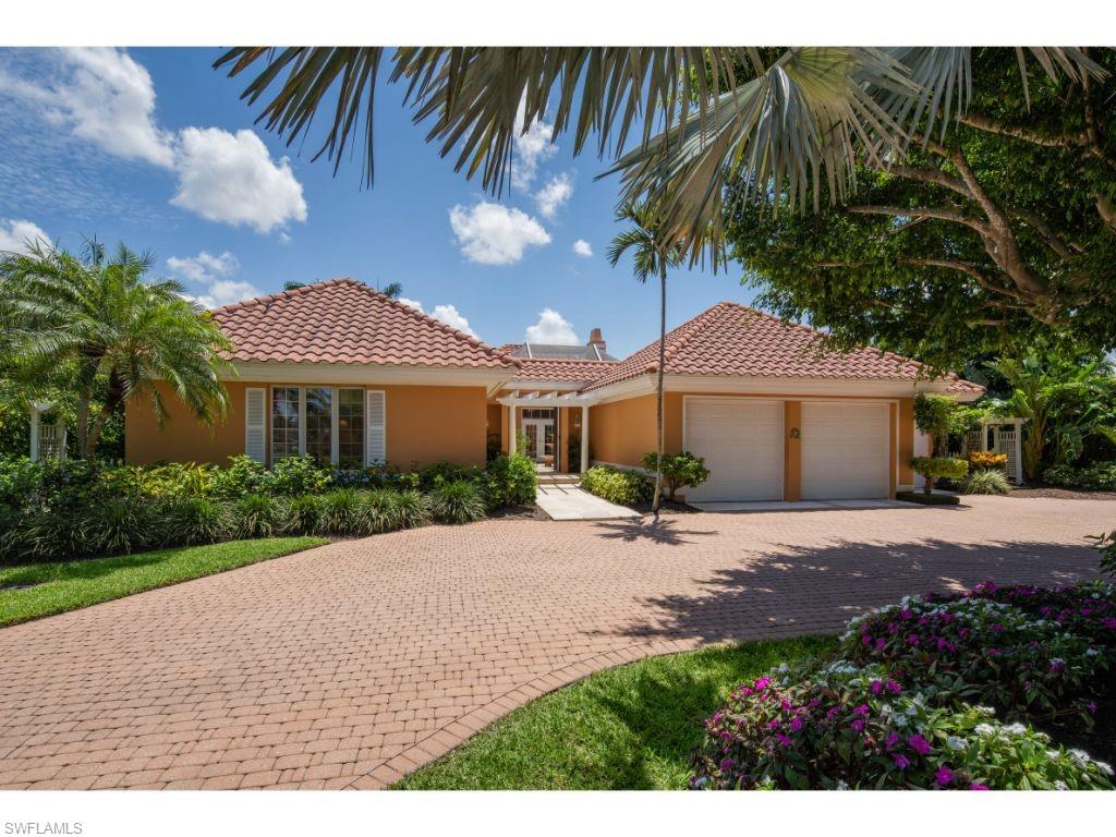 3275 Gin Lane Naples, FL 34102 - Photo 2 of 13 a front view of a house with a garden