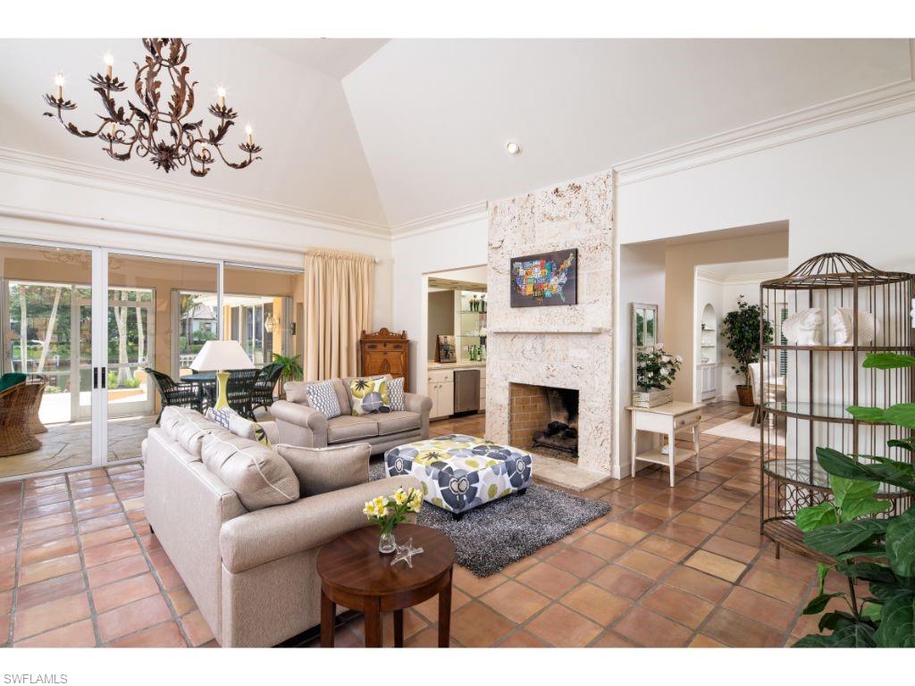 3275 Gin Lane Naples, FL 34102 - Photo 3 of 13 a living room with furniture a fireplace and a large mirror