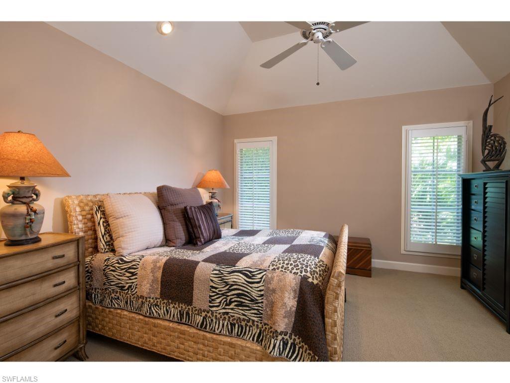 3275 Gin Lane Naples, FL 34102 - Photo 9 of 13 a bedroom with a bed a chandelier and a window