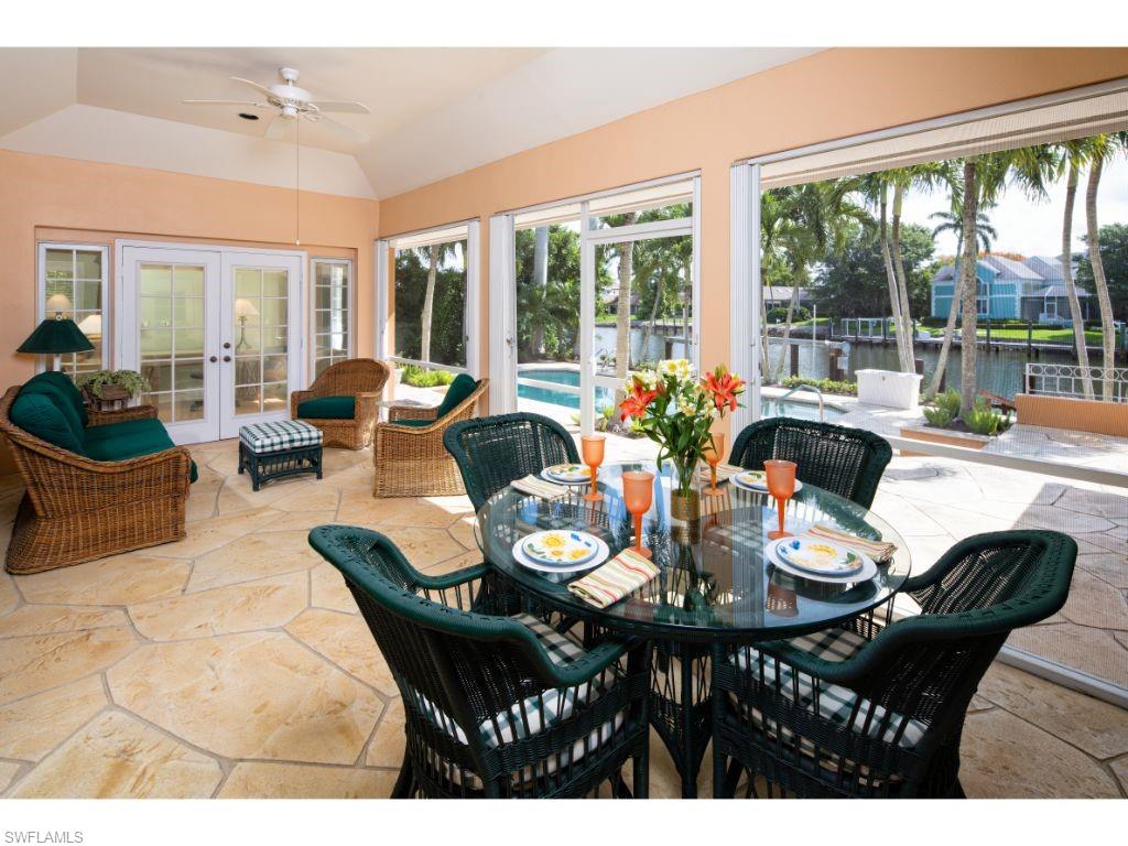 3275 Gin Lane Naples, FL 34102 - Photo 10 of 13 a view of a dining room with furniture large windows and wooden floor