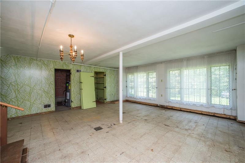 359 Beadling Road Pittsburgh, PA 15228 - Photo 14 of 25 A large (20x20), family room with wall of windows is so bright and light! A newer hot water heater is housed just beyond the open door seen at the left, center of the photo while a handy storage closet is seen just to the right of that.