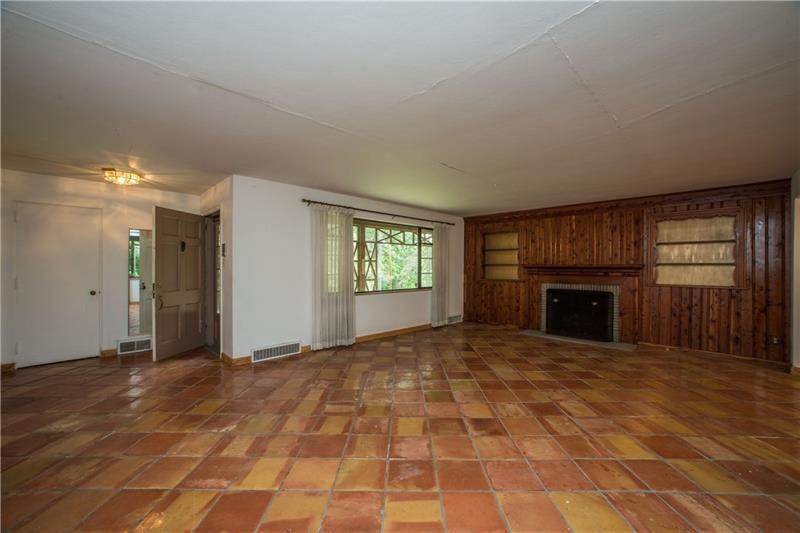 359 Beadling Road Pittsburgh, PA 15228 - Photo 3 of 25 A large, open living room has tiled floors, a large window facing the front of the property, and a fireplace flanked by built-in shelving. There is also a linen/coat closet at the entry. The open door, seen at the left center of the photo, leads to the front porch.