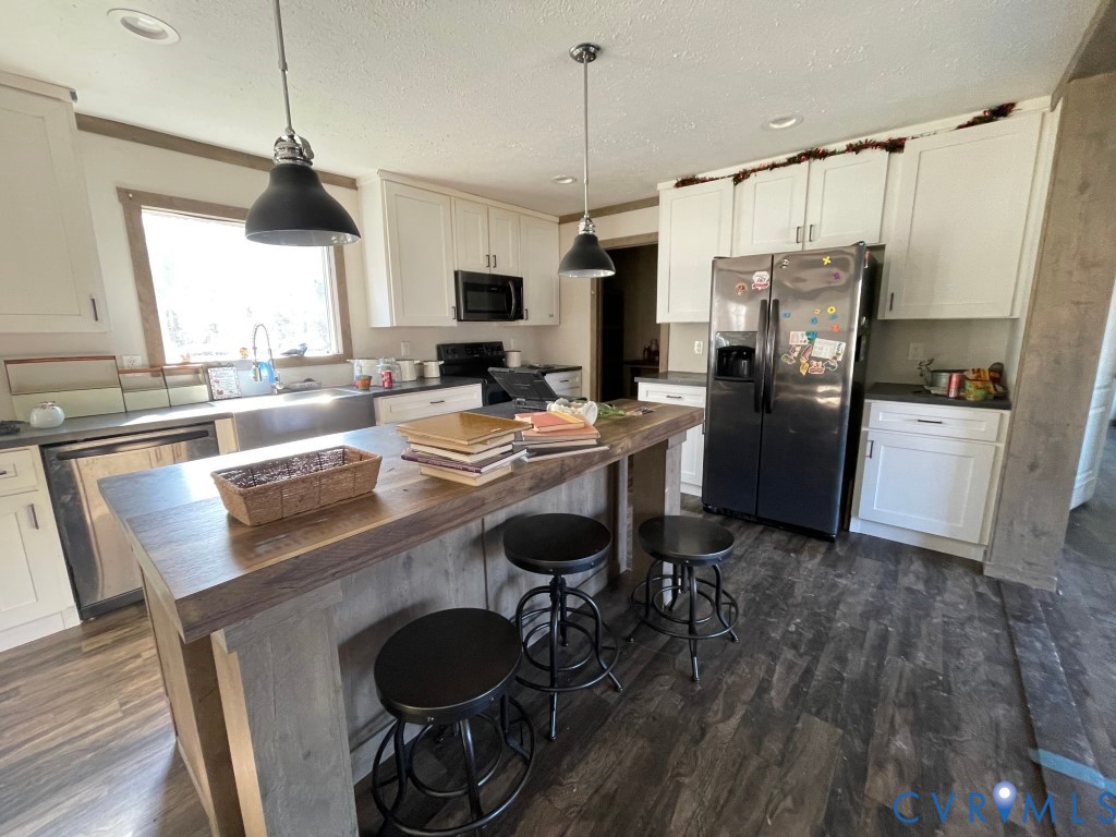 97 Buster Lane West Point, VA 23181 - Photo 11 of 32 a kitchen with a table chairs refrigerator and microwave