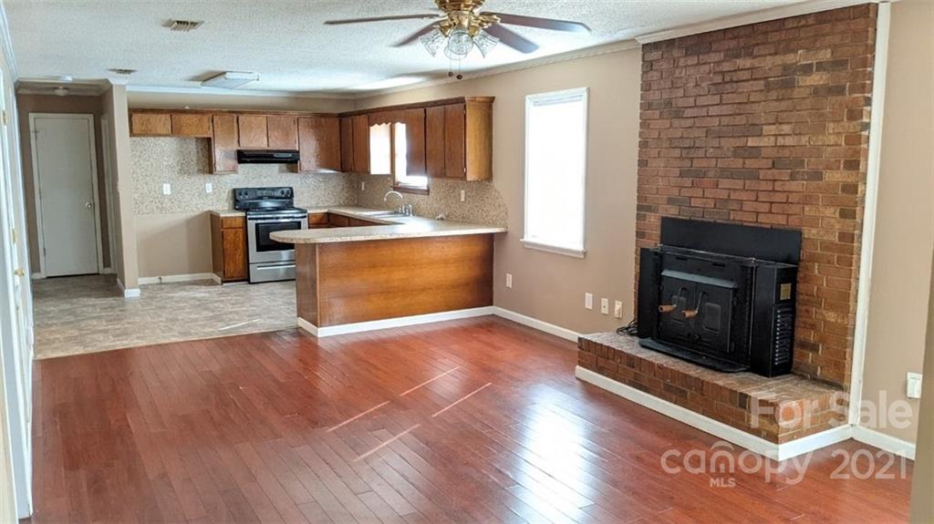 4020 Richardson Road Monroe, NC 28112 - Photo 3 of 18 a open kitchen with granite countertop a stove top oven a sink dishwasher and a fireplace with wooden floor