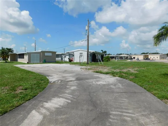 a view of a house with a big yard and a large tree