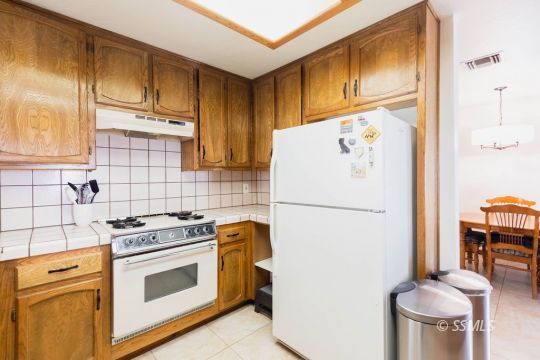 305 South Locust Street Ridgecrest, CA 93555 - Photo 11 of 36 a white refrigerator freezer and a stove sitting inside of a kitchen