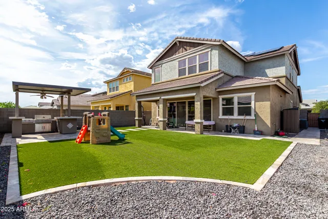 a front view of a house with swimming pool and furniture
