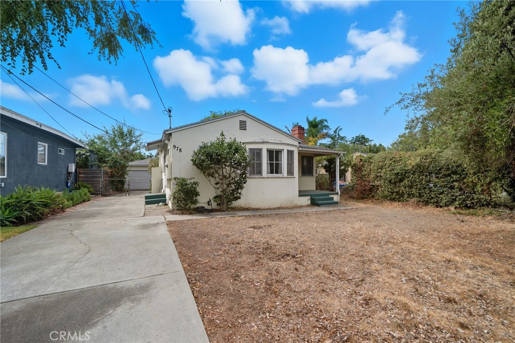 a view of a house with a yard and potted plants