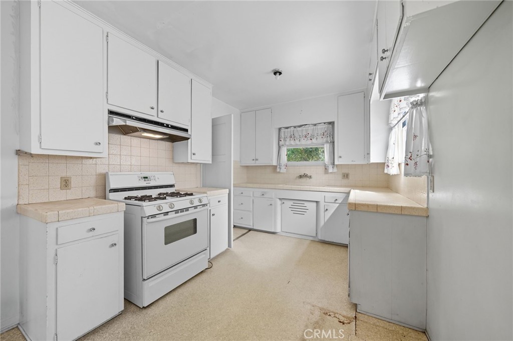 978 West Lehigh Street Altadena, CA 91001 - Photo 36 of 49 a kitchen with a sink stove top oven and cabinets