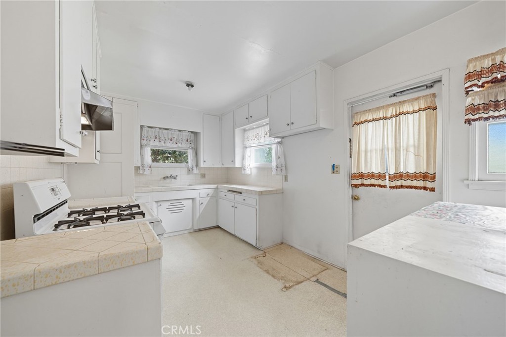 978 West Lehigh Street Altadena, CA 91001 - Photo 37 of 49 a kitchen with a stove a sink dishwasher and a refrigerator with wooden floor