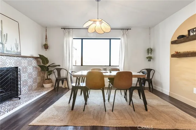 a dining room with wooden floor a chandelier a wooden table and chairs