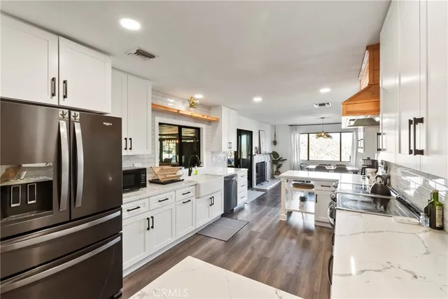 a large kitchen with stainless steel appliances lots of counter space and windows
