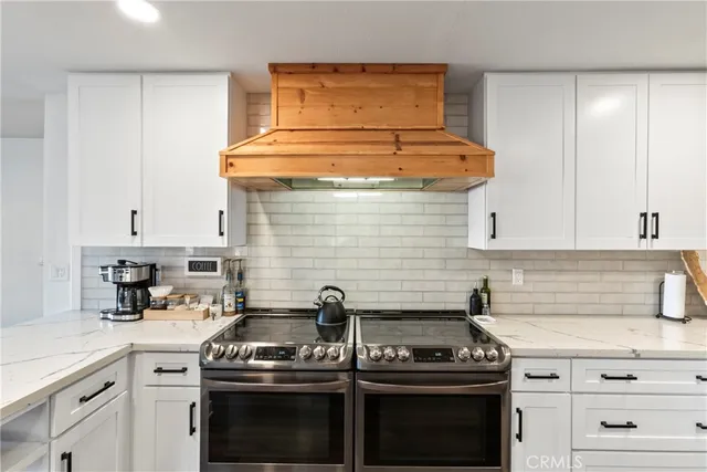 a kitchen with a stove and white cabinets