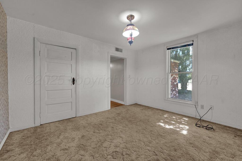 404 Chester Avenue Panhandle, TX 79068 - Photo 18 of 33 wooden floor in an empty room with a window