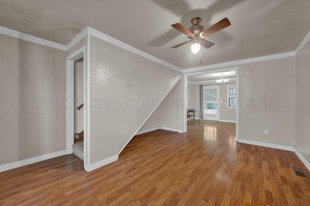404 Chester Avenue Panhandle, TX 79068 - Photo 4 of 33 wooden floor in an empty room with a window