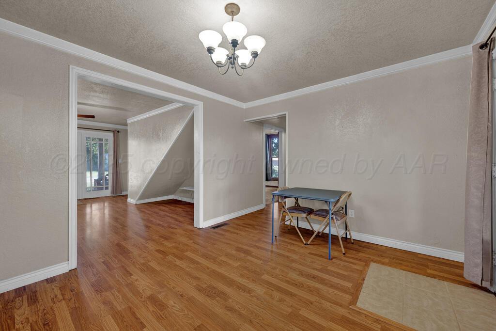 404 Chester Avenue Panhandle, TX 79068 - Photo 7 of 33 a view of a room with wooden floor chandelier and entryway