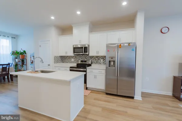 a kitchen with stainless steel appliances a refrigerator sink and microwave