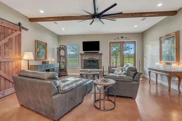 a living room with furniture a flat screen tv and a fireplace