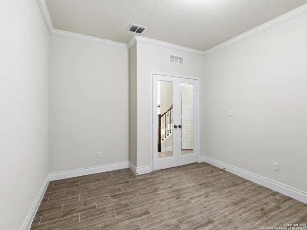 a view of empty room with wooden floor