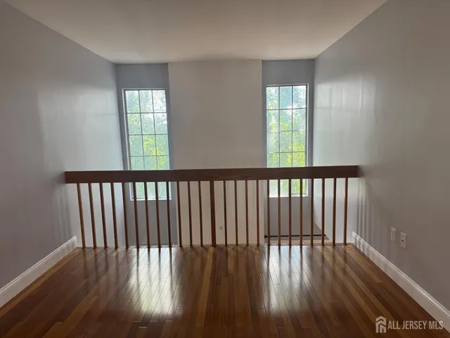 a view of a hallway with wooden floor and staircase