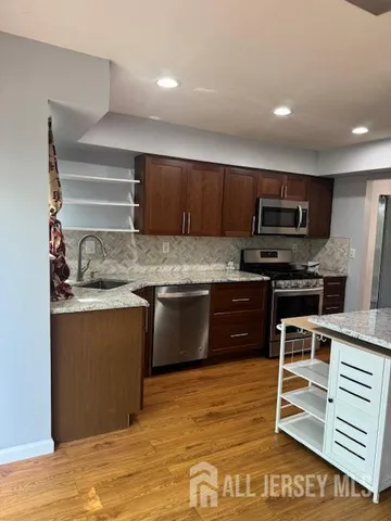 a kitchen with kitchen island granite countertop a stove cabinets and microwave