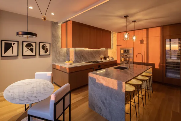 a kitchen with kitchen island granite countertop a table chairs in it and wooden floors