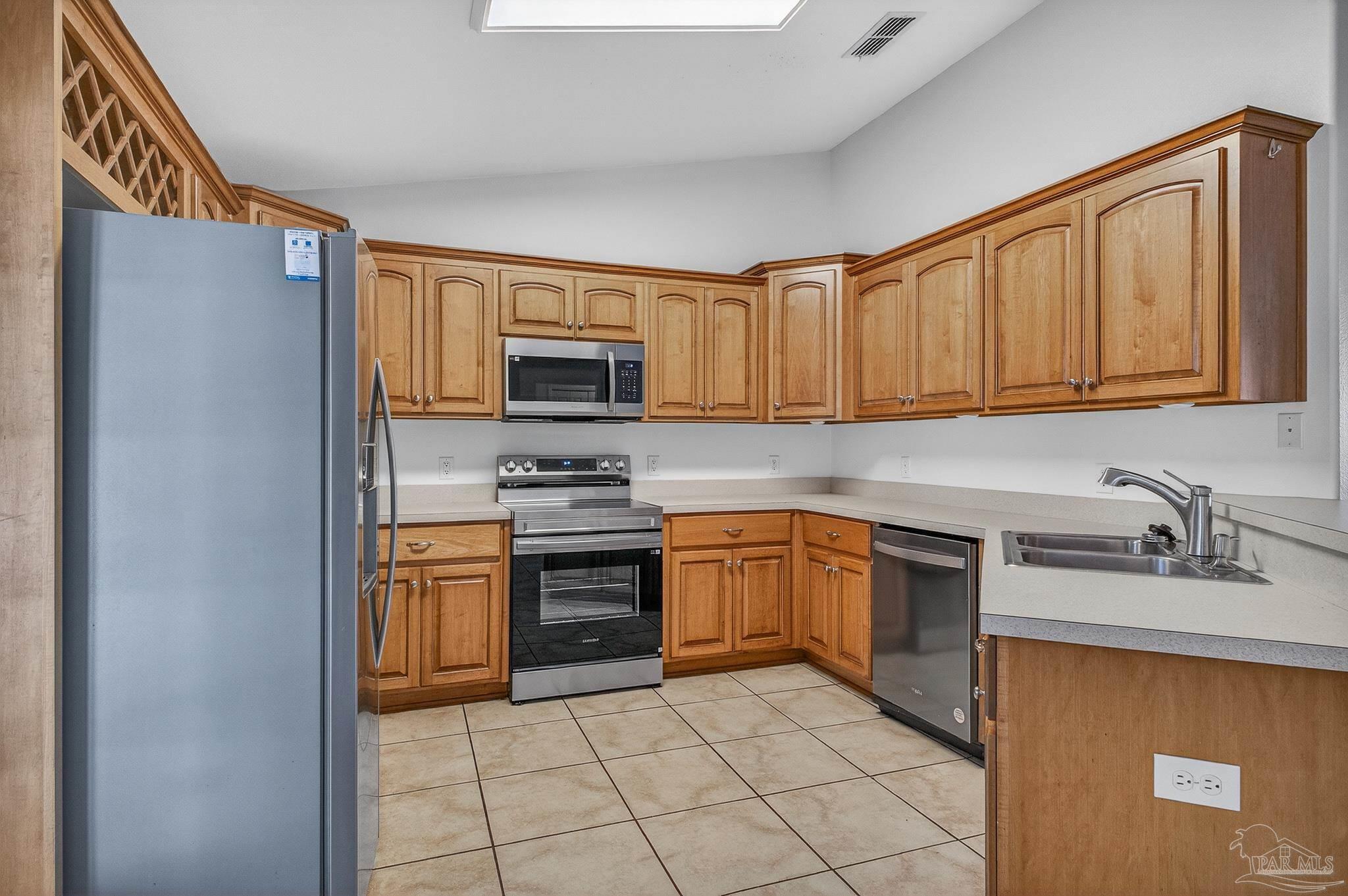 6050 Antelope Street Milton, FL 32570 - Photo 15 of 58 a kitchen with stainless steel appliances granite countertop a sink stove and refrigerator