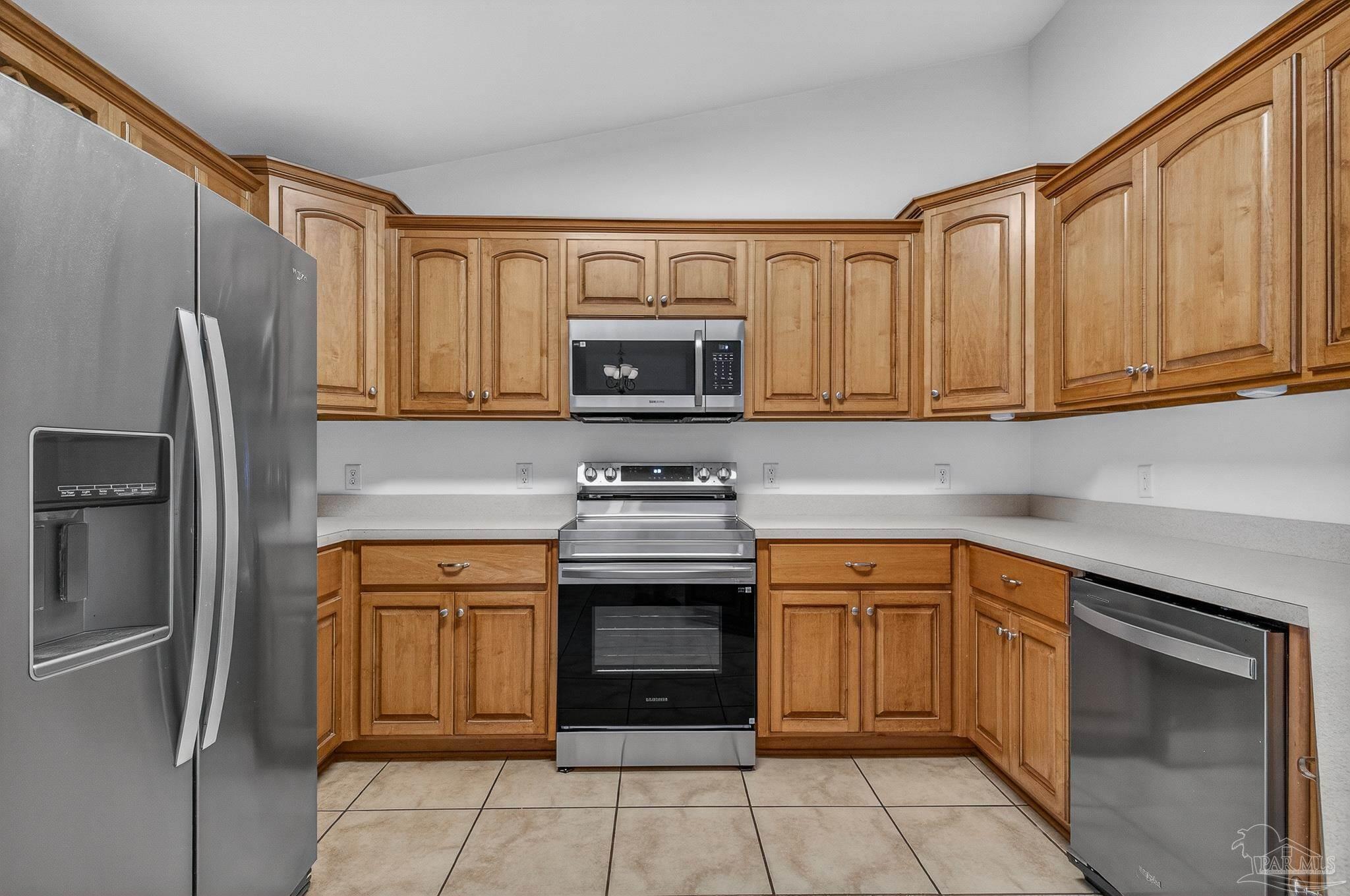 6050 Antelope Street Milton, FL 32570 - Photo 16 of 58 a kitchen with stainless steel appliances granite countertop a stove top oven a refrigerator and white cabinets