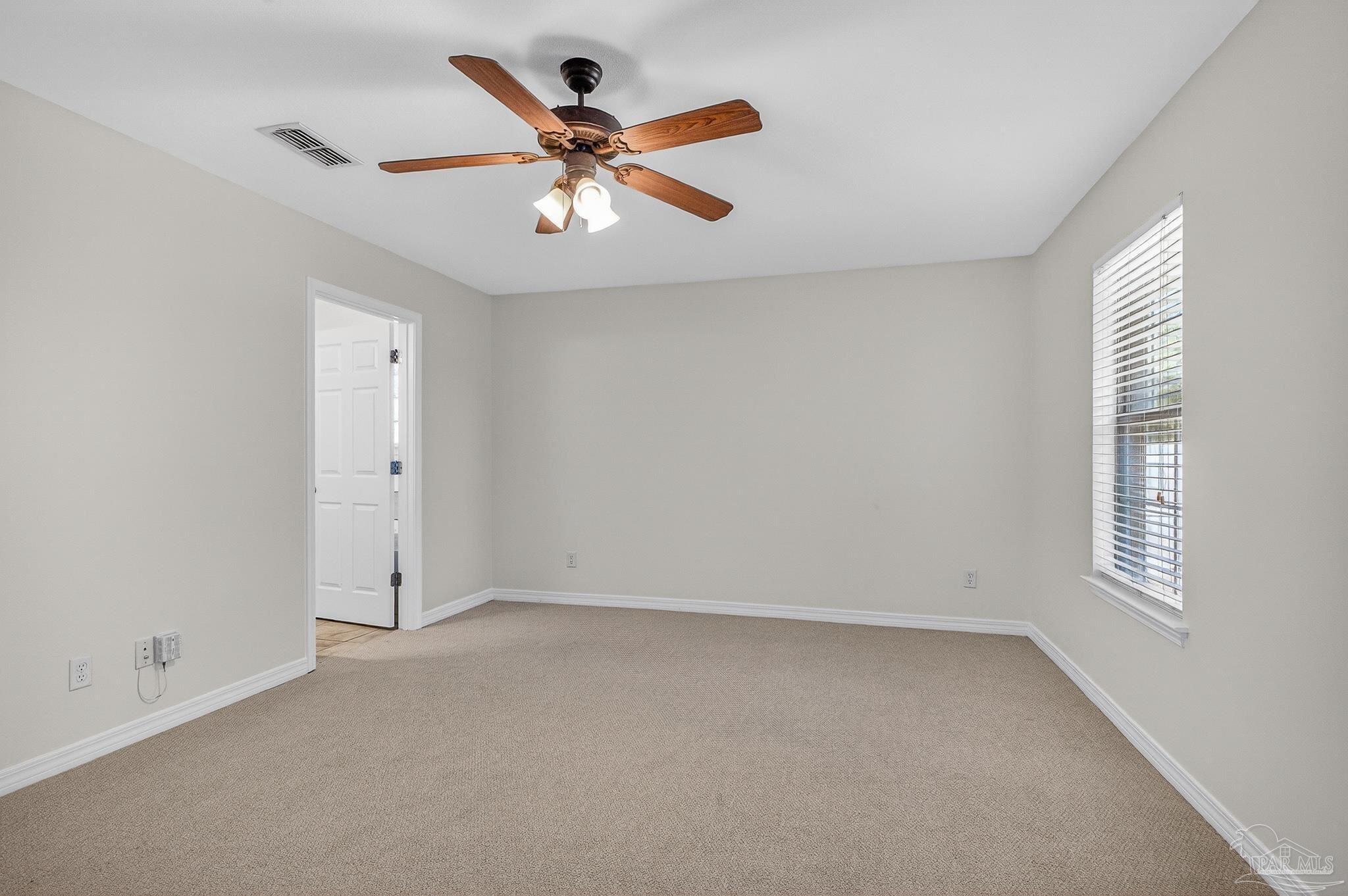 6050 Antelope Street Milton, FL 32570 - Photo 44 of 58 an empty room with a window and a fan