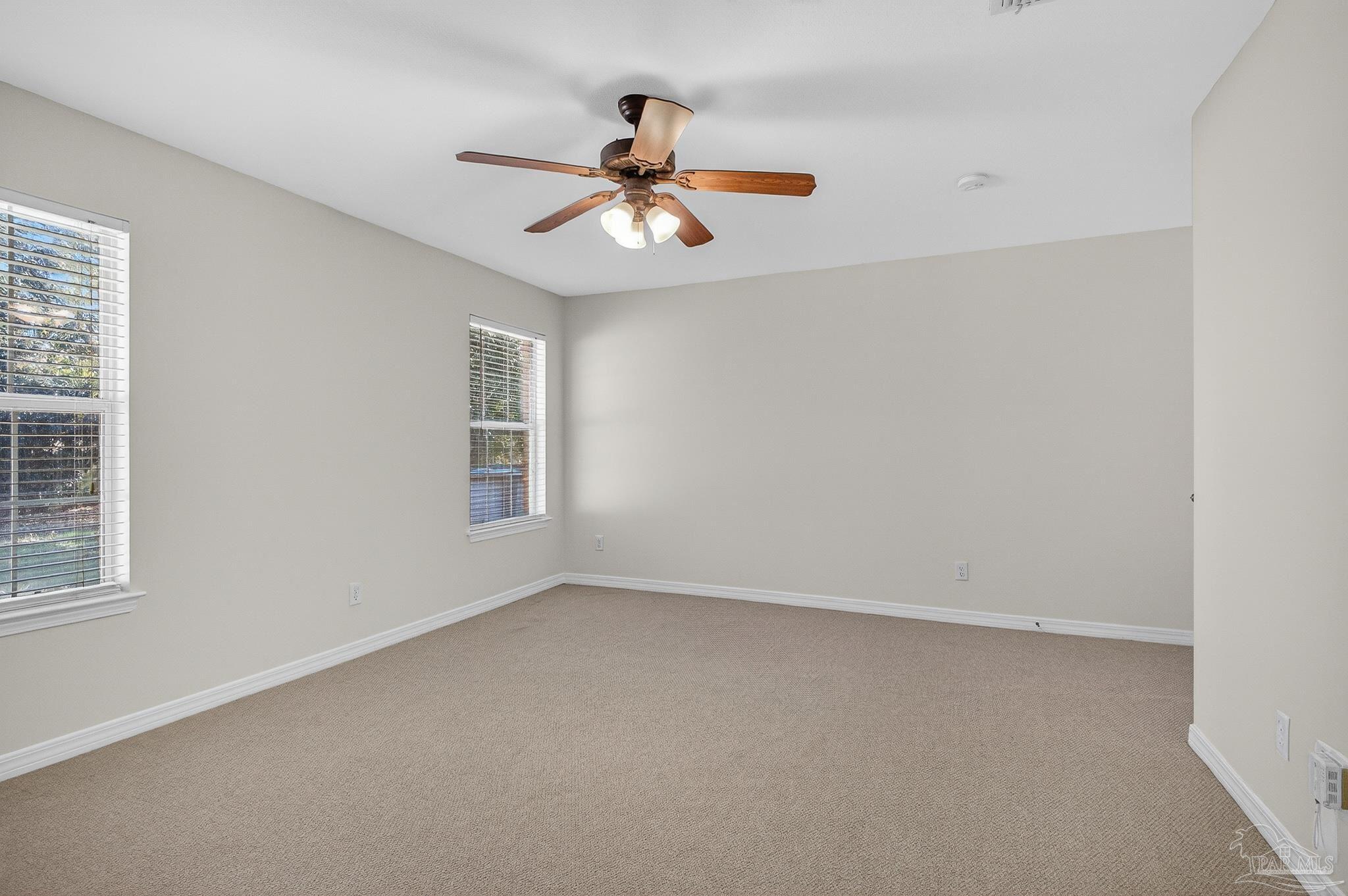 6050 Antelope Street Milton, FL 32570 - Photo 45 of 58 an empty room with windows and chandelier fan