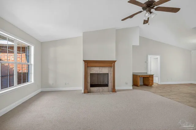 an empty room with a fireplace and windows