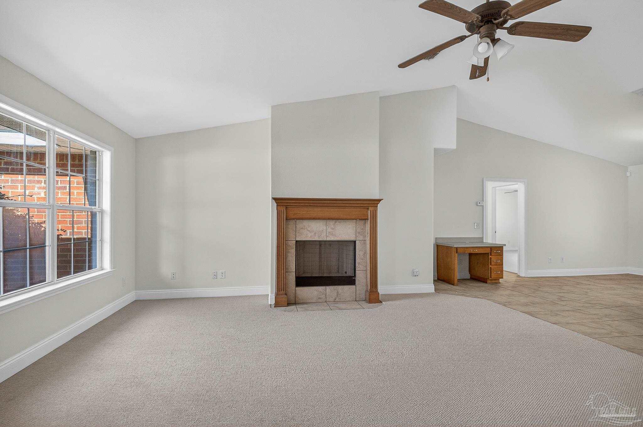 6050 Antelope Street Milton, FL 32570 - Photo 6 of 58 an empty room with a fireplace and windows