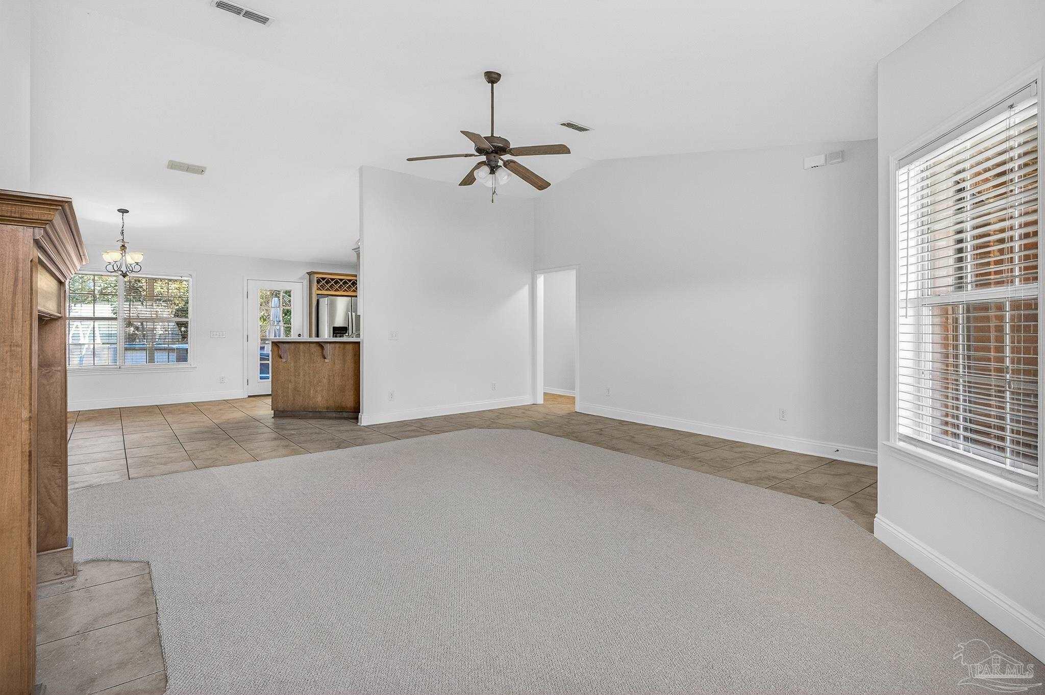 6050 Antelope Street Milton, FL 32570 - Photo 8 of 58 en empty room with windows and ceiling fan