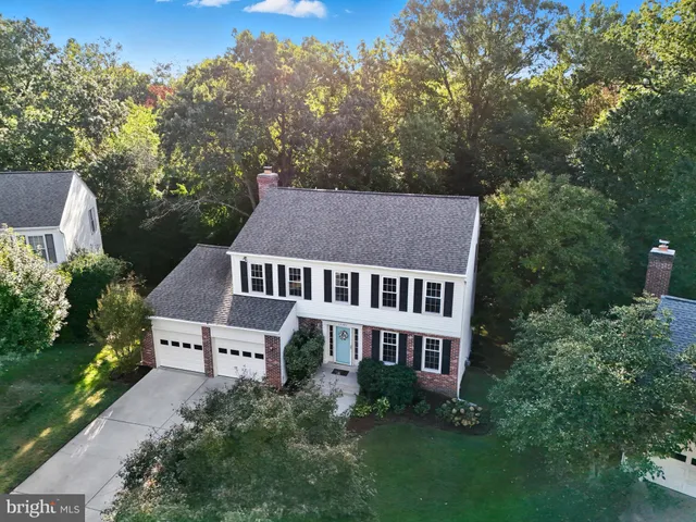 aerial view of a house with yard and trees in the background