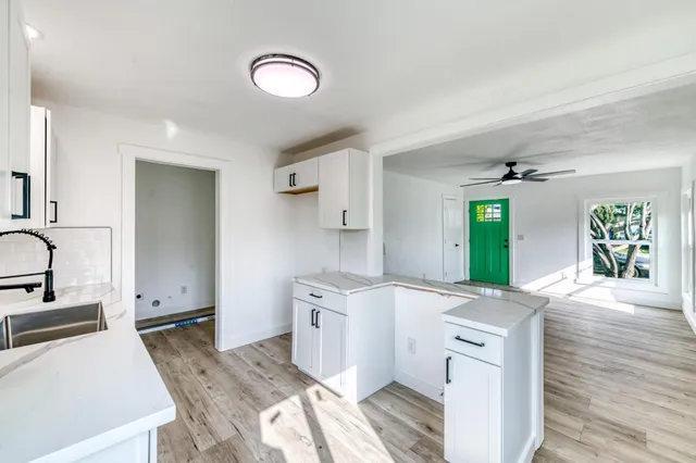a view of a kitchen with a sink dishwasher stove and wooden cabinets