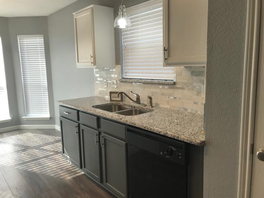 3305 Rustic Meadow Trail Mansfield, TX 76063 - Photo 4 of 12 Kitchen area featuring a double basin stainless steel sink with a gooseneck faucet, light granite-style countertops, and a full tile backsplash