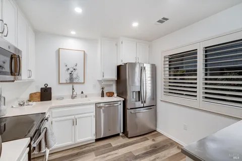a kitchen with a sink stainless steel appliances and cabinets