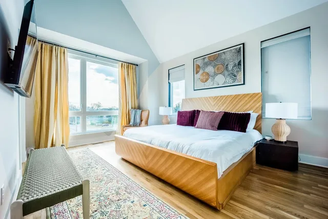 a large bedroom with a bed and glass window