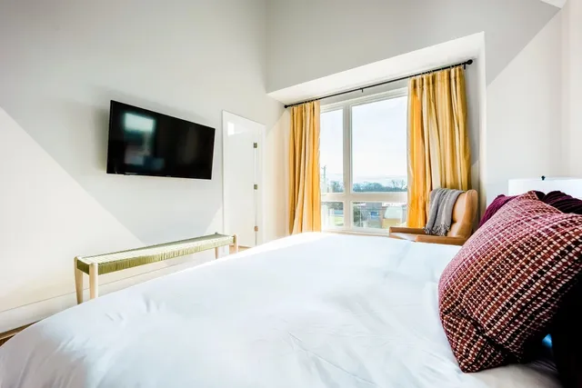 a bedroom with a bed and a flat screen tv