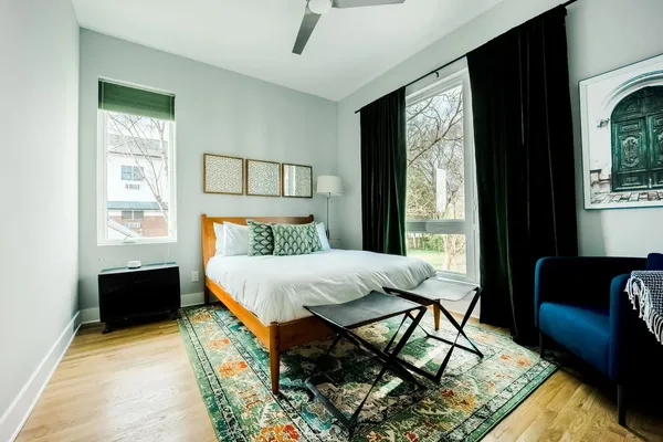 a bed sitting in a bedroom next to a window with wooden floor